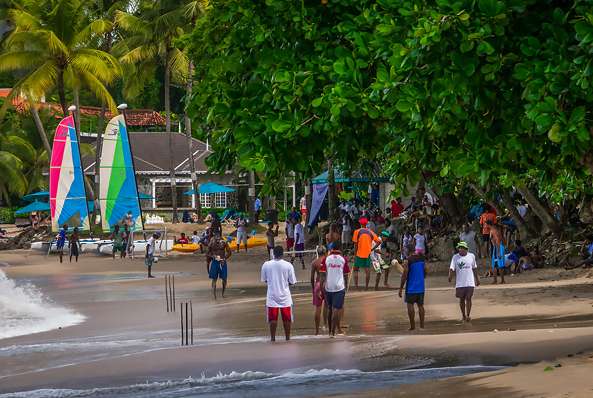 Жители Сент-Люсии играют на пляже в крикет